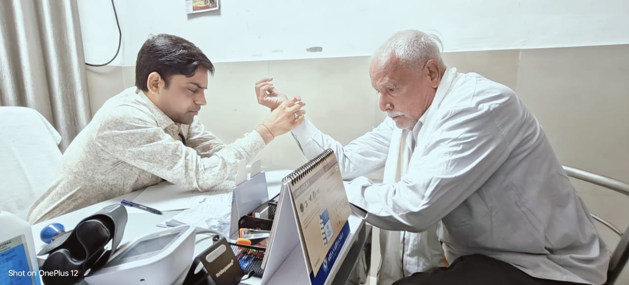 रायबरेली-नाड़ी परीक्षा से प्रकृति परीक्षण एवं इलाज करते हुए एम्स के आयुष चिकित्साधिकारी डॉ एच के पारीक।